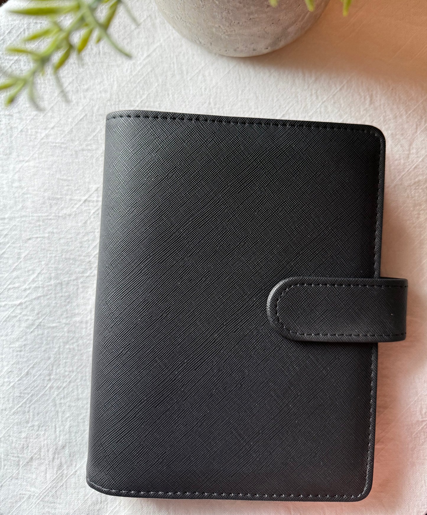 Black planner cover on a textured surface