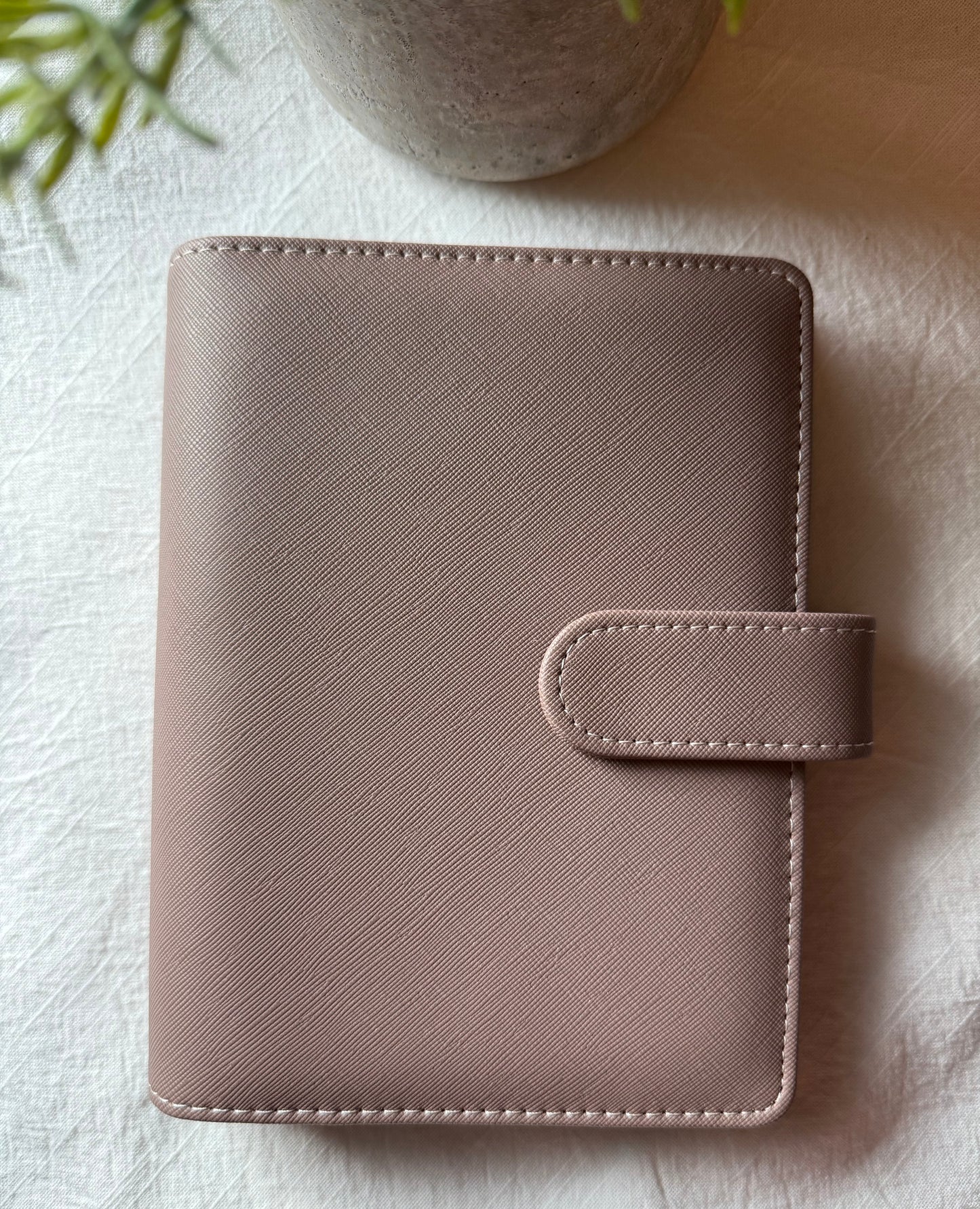 taupe leather planner on a light textured surface